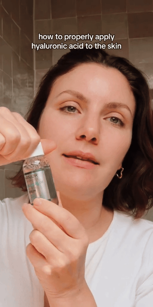 Woman demonstrating how to properly apply garnier skin naturals serum on her face