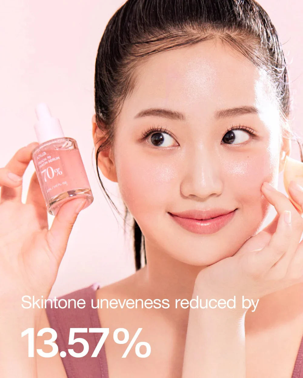 Young woman holding Anua Niacin Hyaluronic Serum bottle showing clear glowing skin