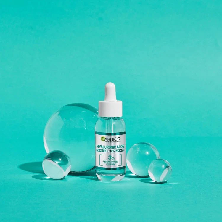 Garnier Skin Naturals Hyaluronic Aloe Serum bottle with clear glass spheres on turquoise background