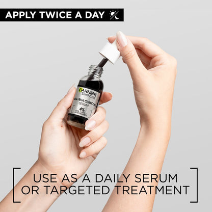 Hands holding Garnier Skin Naturals activated charcoal serum bottle with dropper for daily skincare use