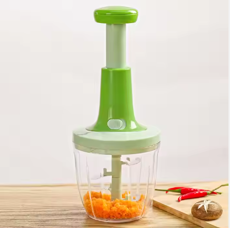 Souqzila handheld food chopper in green with clear container and chopped vegetables inside